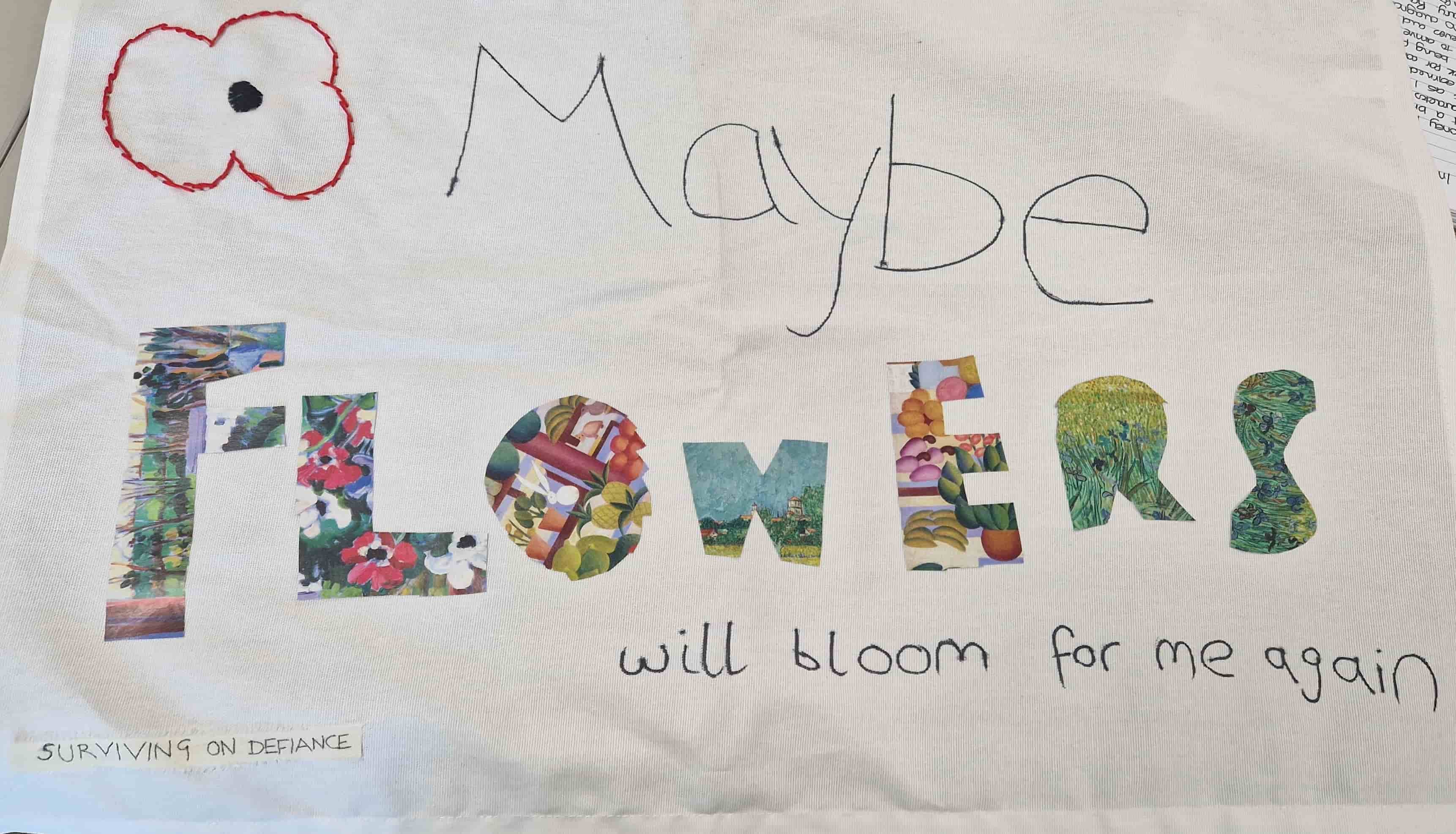 A white tea towel embroidered with the outline of a poppy, the words 'maybe flowers will bloom for me again' in pen and floral collage, and the words 'surviving on defiance' on a piece of tailor's tape